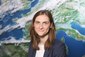 Portrait Alina-Louise Kramer vor der Rückwand mit dem Motiv Satellitenbild (Quelle DWD)